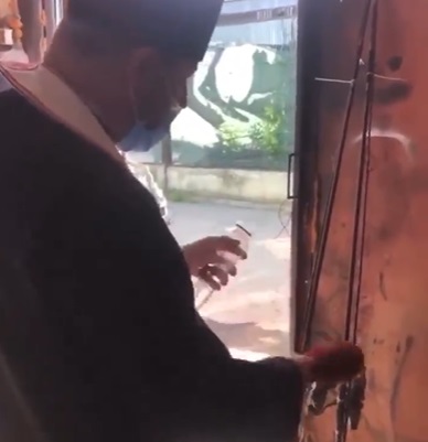 Un preot sfințește undițe cu apă și busuioc, &icirc;ntr-un garaj