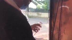 Un preot sfințește undițe cu apă și busuioc, într-un garaj