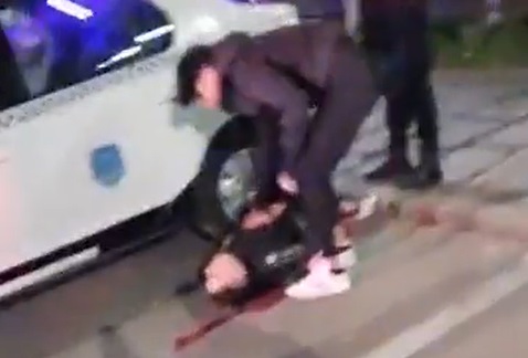 Un tânăr, care pare plin de sânge căzut pe jos, în timpul protestelor.