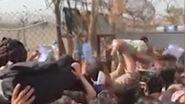 Mamele disperate își aruncă bebelușii peste gardul de sârmă, pentru a fi salvați de soldați