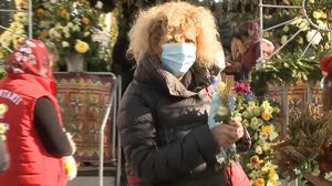 Credincioasa care a șters racla cu moaște cu măstile de protecție