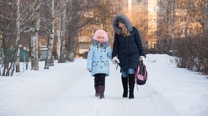 Elevă însoțită de mama ei, în drum spre școală