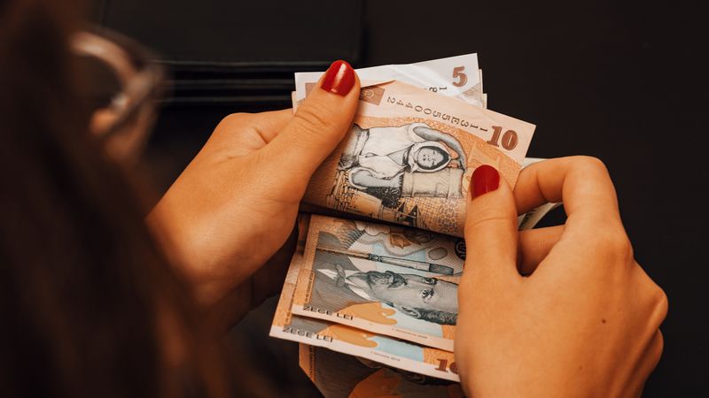 Femeie cu ochelari, numără bani