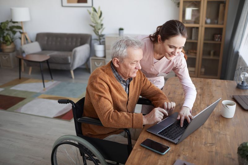 Persoană cu dizabilități, asistentă, la laptop
