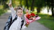 Elev cu un buchet de flori, în drum spre școală