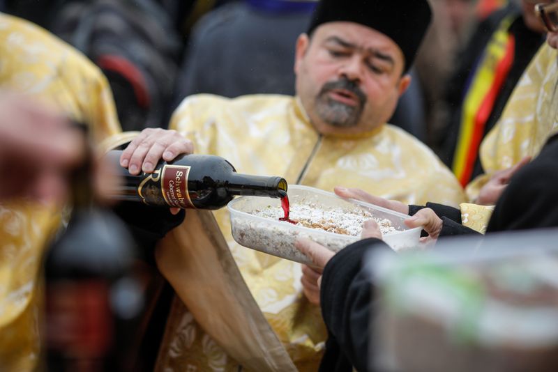 Preot, stropește coliva cu vin