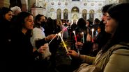 Credincioși în biserică, aprind lumânări de Înviere