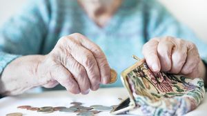 Pensionară, numără banii din portofel