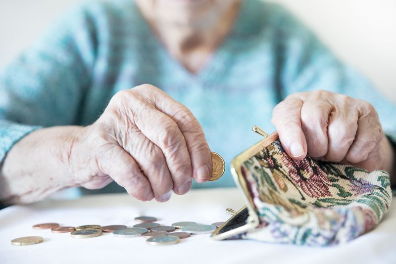 Pensionară, numără banii din portofel