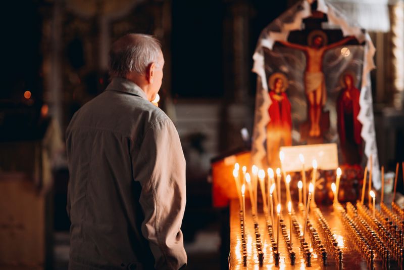 Credincioși în biserică, lumânări aprinse