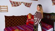 Tânără îmbrăcată în costum tradițional, pâine proaspătă