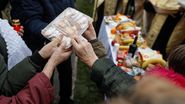 Credincioși în curtea bisericii, împart alimente