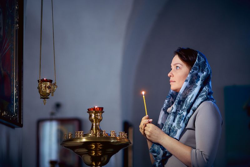 Femeie, se roagă &icirc;n biserică