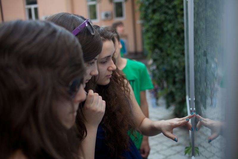 Elevi și părinți care privesc tabelul cu rezultatele de la Evaluarea Națională