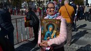 Femeie care ține în brațe icoana Sfintei Parascheva de la Iași