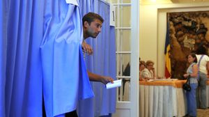 Cetățean care iese din cabina de vot