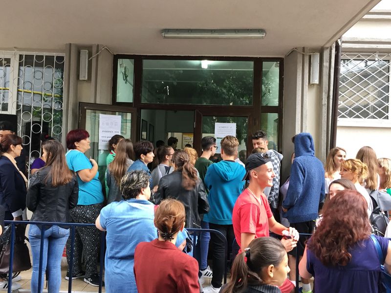 Elevi și părinți în curtea școlii