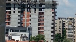 Barbatul se afla pe macara, iar negociatorii striga la el de pe terasa blocului (Foto: dcnews.ro)