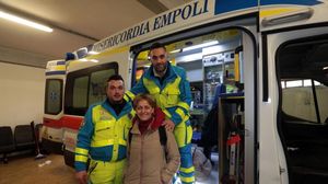 Asistenta Adele, alaturi de cei doi voluntari, langa ambulanta cu care au transportat-o acasa pe romanca
