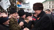 Klaus Iohannis, inconjurat de barbati ce poarta caciuli asemanatoare cu a lui