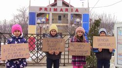"Micul Hercule" si cu familia lui au protestat impotriva ordonantelor in fata primariei din sat: "La noi in comuna, primaria mananca banii nostri ca magiunul pe paine!" Uite ce pancarte a avut Giuliano Stroe!
