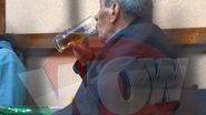 Mitica Popescu duce paharul la gura, atent la ceea ce spune camaradul sau