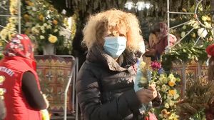 Credincioasa care a șters racla cu moaște cu măstile de protecție