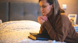 Tânără, se roagă în dormitor, înainte de somn