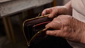 Vârstnică, numără toți banii din portofel