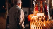 Credincioși în biserică, lumânări aprinse