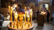 Lumânări aprinse, credincioși în biserică