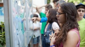 Elevi și părinți care privesc tabelul cu rezultatele de la Evaluarea Națională