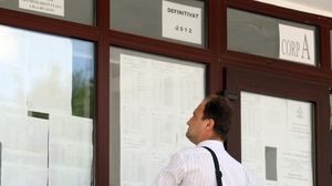 profesor cu spatele priveste panoul cu rezultate