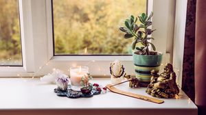 statuie budha, lumanare, planta norocoasă, feng shui