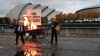 Un bărbat deghizat în Boris Johnson a protestat în fața centrului care a găzduit COP26. Acesta a incendiat o barcă