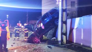 A rămas cu mașina suspendată într-un gard de beton după ce s-a urcat băut la volan