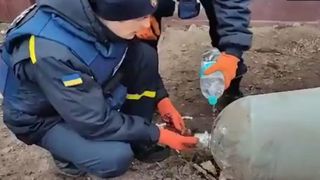 Momentul înfiorător în care doi ucraineni dezamorsează o bombă cu mâinile goale şi o sticlă mică de apă: "Un curaj uluitor"