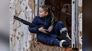 Imaginea care a făcut înconjurul lumii. O fetiță din Kiev a fost fotografiată cu o acadea și cu o pușcă în mână
