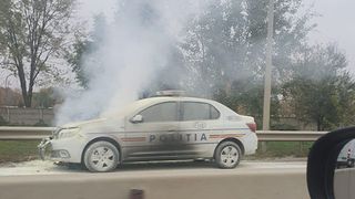 O mașină de poliție a luat foc în mers