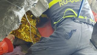 Salvatorii români au găsit un copil decedat, prins între părinți, sub o clădire