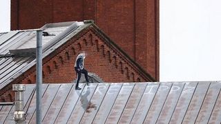 Unele fotografii arată că bărbatul &icirc;ncearcă să dea semnale, iar &icirc;ntr-o imagine acesta face o formă de inimă cu m&acirc;inile, &icirc;n timp ce poartă ceea ce pare a fi un top impermeabil