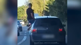 Un bărbat a fost sancționat, după ce a ieșit pe geamul mașinii &icirc;n mers, cu o sticlă de alcool &icirc;n m&acirc;nă