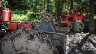 Tractoare articulate de exploatare forestieră folosite pentru a manipula trunchiurile de copaci de pe pantele abrupte ale pădurii.