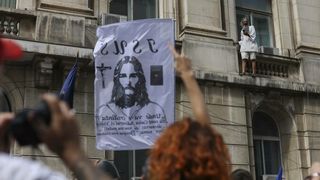 Un bărbat s-a urcat pe clădire flutur&acirc;nd drapelul Rom&acirc;niei.