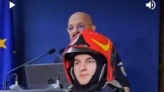 Raed Arafat, ajutat de un pompier să prezinte echipamentul de protecție