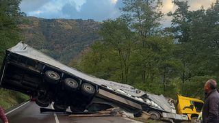 VIDEO - Accident rutier cumplit în localitatea Câineni. Șoferul unui autotren a pierdut controlul volanului și s-a răsturnat în afara părții carosabile
