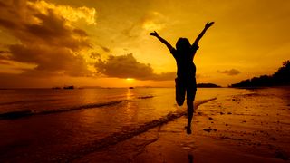 femeie fericita pe plaja