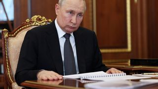 vladimir putin cu un document la birou