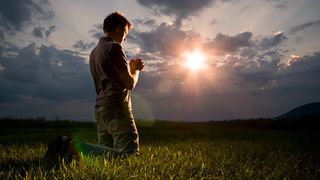 barbat care se roaga in genunchi