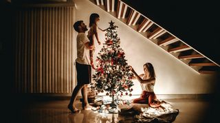 familie care impodobeste bradul de craciun